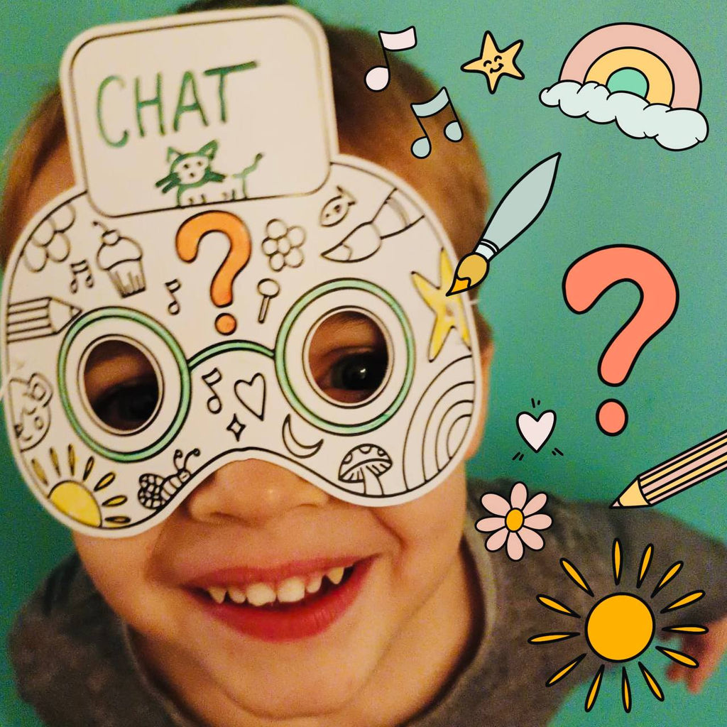 Enfant portant notre masque qui suis-je, avec des dessins de soleil, fleur, point d'interrogation, notes de musique 