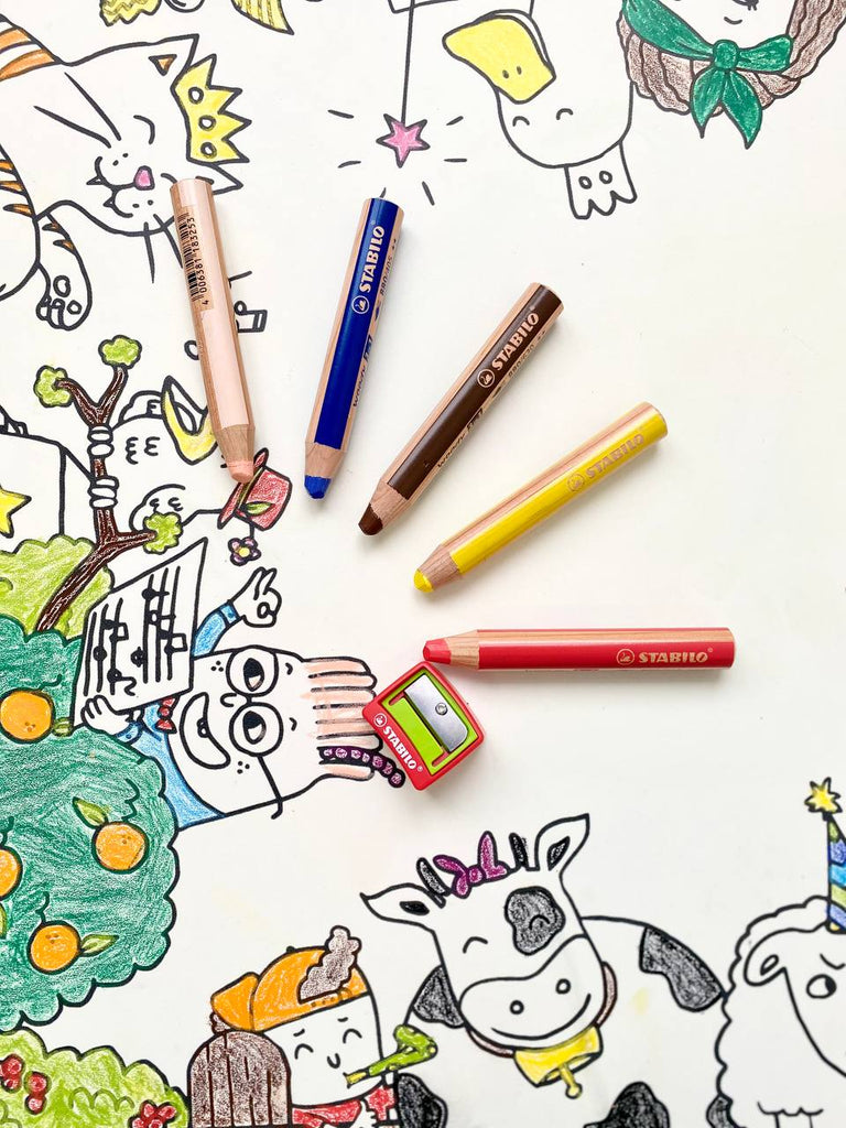 Crayons gras posés sur une coloritable sur le thème des animaux de la ferme